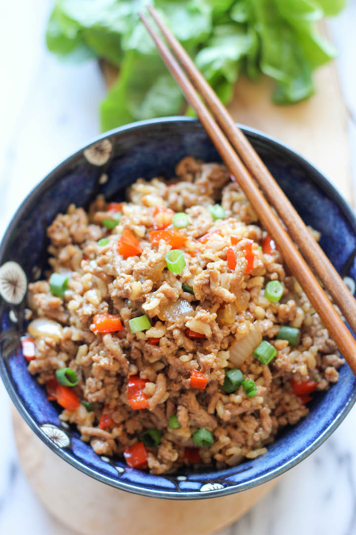 A bowl of cooked ground turkey mixed with hoisin sauce, soy sauce, ginger, cooked rice and green onions.