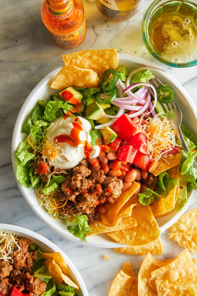 Taco Salad - With taco-seasoned ground beef, crisp lettuce, beans, avocado and cheese! Top with a dollop of sour cream. So quick, so good!