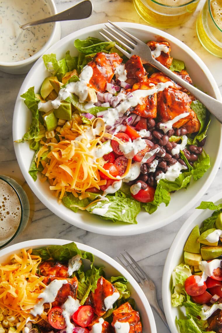 BBQ Chicken Salad - Smoky BBQ chicken, corn, tomatoes, black beans, avocado + cheese drizzled with homemade Ranch. An instant family favorite!