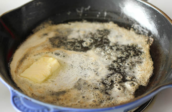 Butter melting in a hot skillet.