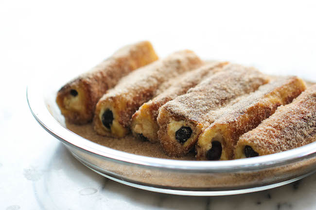Blueberry French Toast Roll Ups - A fun twist on French toast stuffed with cream cheese and blueberries, tossed in cinnamon sugar goodness!