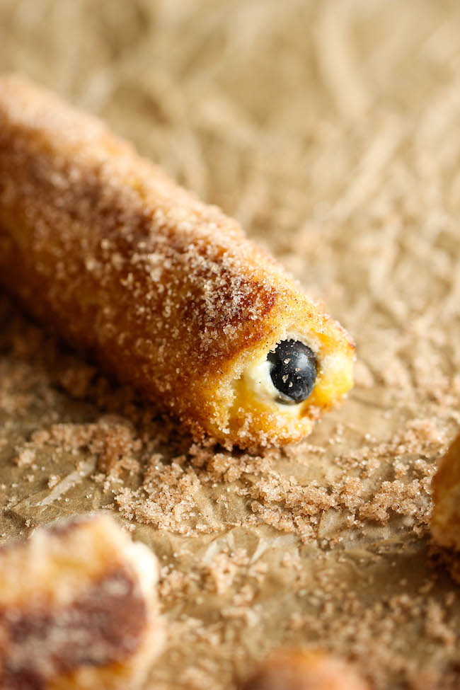 Blueberry French Toast Roll Ups - A fun twist on French toast stuffed with cream cheese and blueberries, tossed in cinnamon sugar goodness!