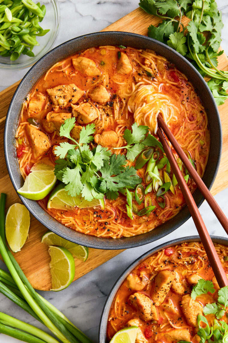 Thai Red Curry Noodle Soup - So much better than takeout! Packed with bites of tender chicken, rice noodles, cilantro, basil and lime juice!