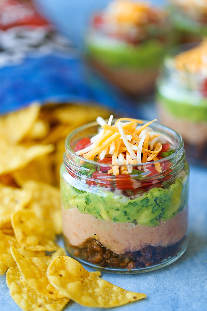 5-Layer Mason Jar Taco Dip - Everyone’s favorite dip in mason jar form! Everything is layered in individual jars so it makes for the easiest serving! Loaded with taco beef, refried beans, guacamole, pico de gallo, and cheese!