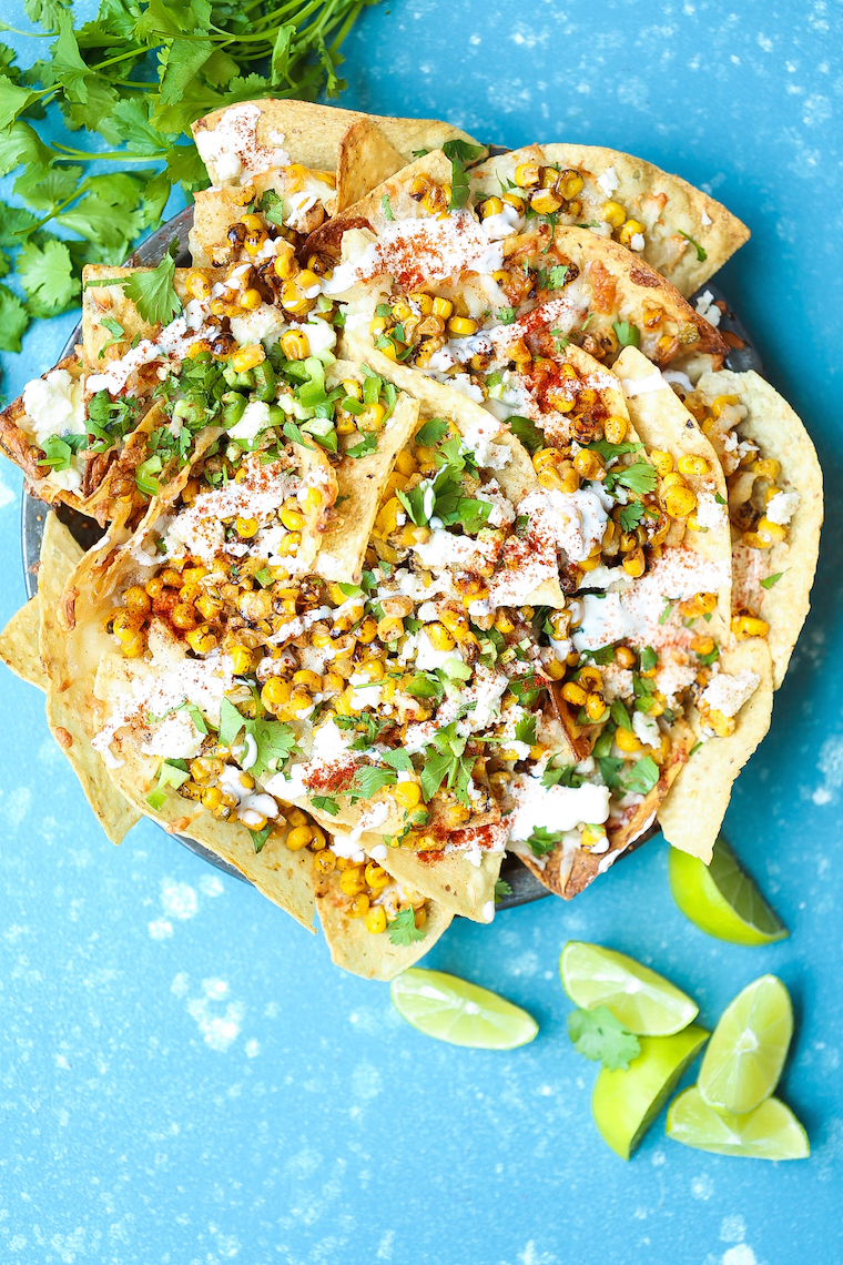Mexican Street Corn Nachos - Everyone's favorite Mexican elote is made into the BEST nachos! Loaded with roasted corn, lime, chili powder and Mexican crema!