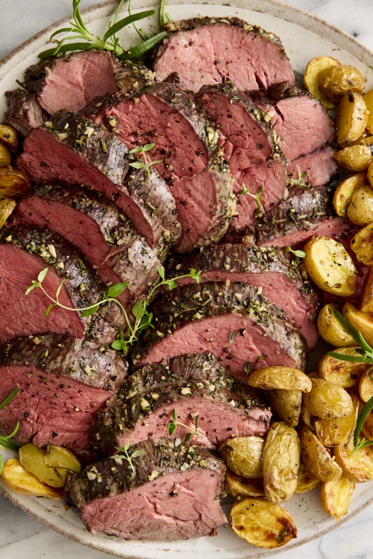 Garlic Rosemary Beef Tenderloin - Cooked low + slow, this is the most perfect (and only way to cook) tenderloin! So easy, so tender, so good.