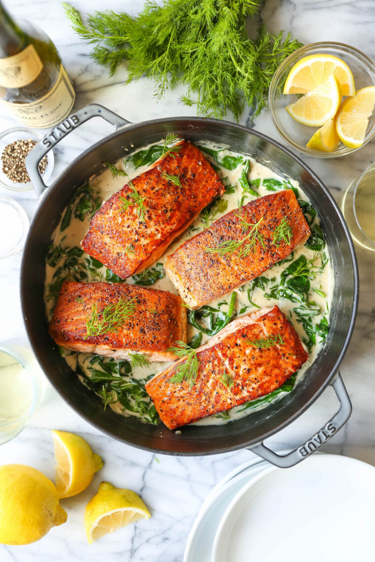 Salmon with Garlic Cream Sauce - Perfectly pan-seared salmon served with the most irresistible garlicky cream sauce with sneaked in spinach!