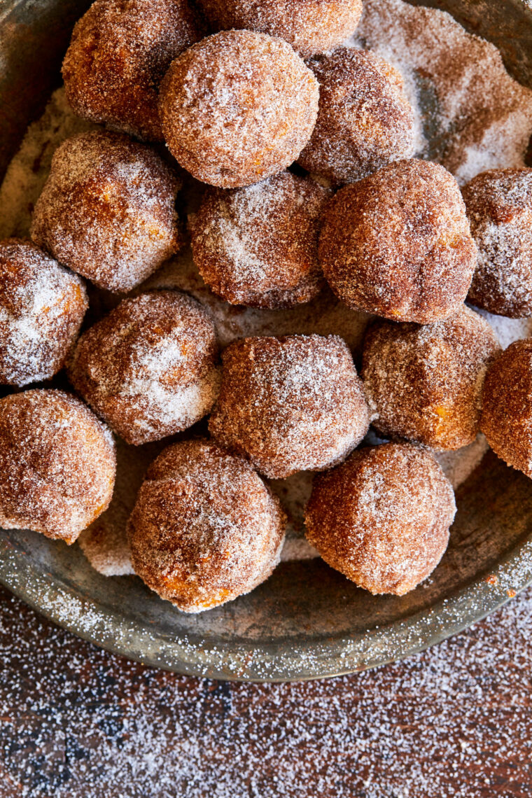 Pumpkin Donut Holes - The most irresistible mini pumpkin muffins smothered in cinnamon sugar goodness! Perfect for breakfast, lunch + dinner!