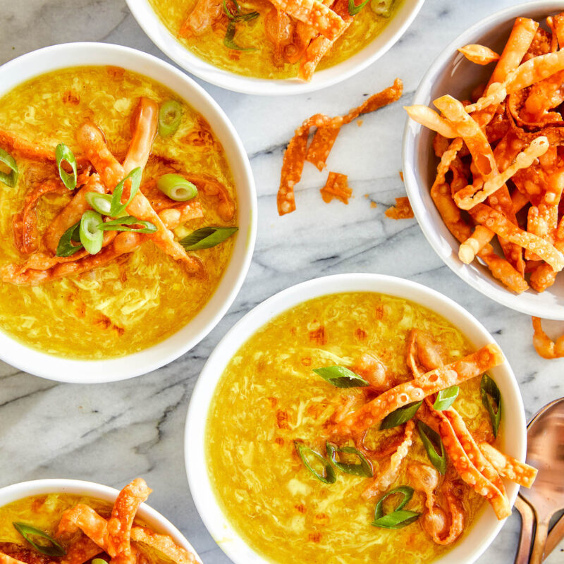 Bowls of Egg Drop Soup, served with won ton strips, and garnished with green onions.