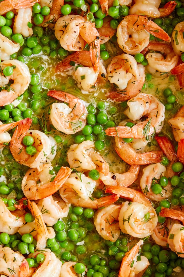 Garlic Shrimp and Peas - Juicy, tender shrimp swimming in a pool of garlicky, buttery goodness. Serve with crusty bread or pasta. SO SO GOOD!