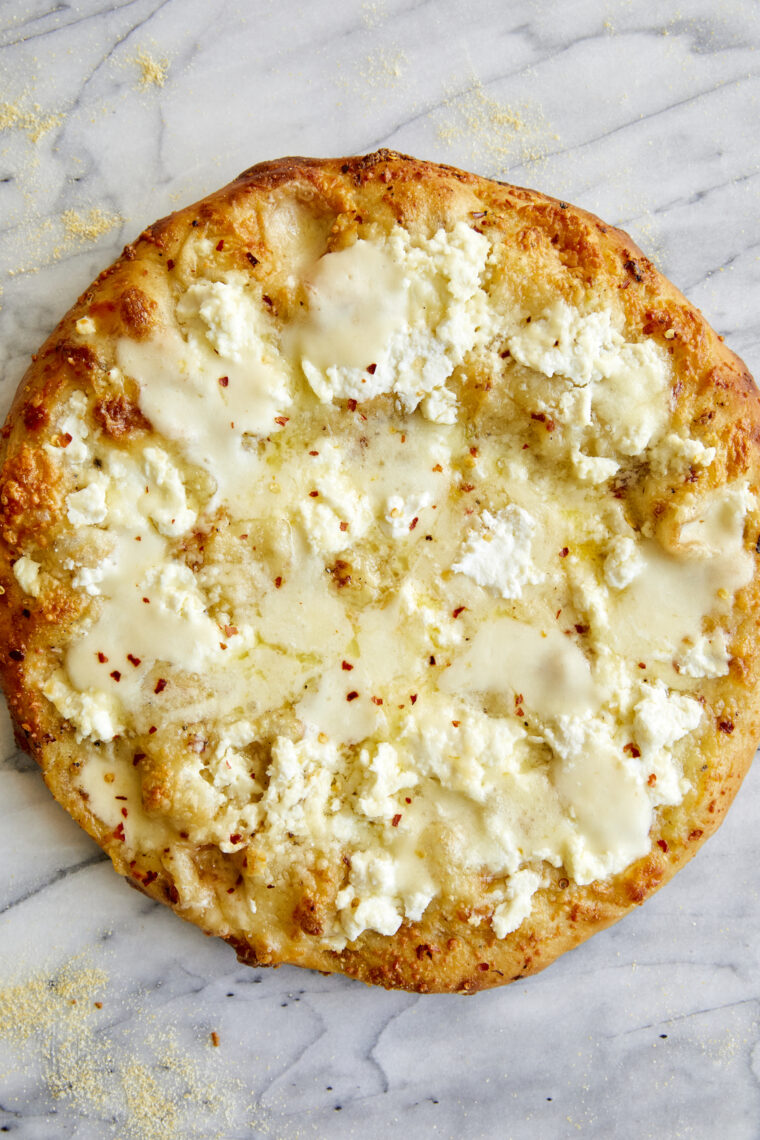 Pizza blanca: hecha con 3 quesos diferentes (¡aquí no hay salsa de tomate!) y cubierta con aceite de oliva virgen extra con sabor a ajo.  ¡Sí, por favor!