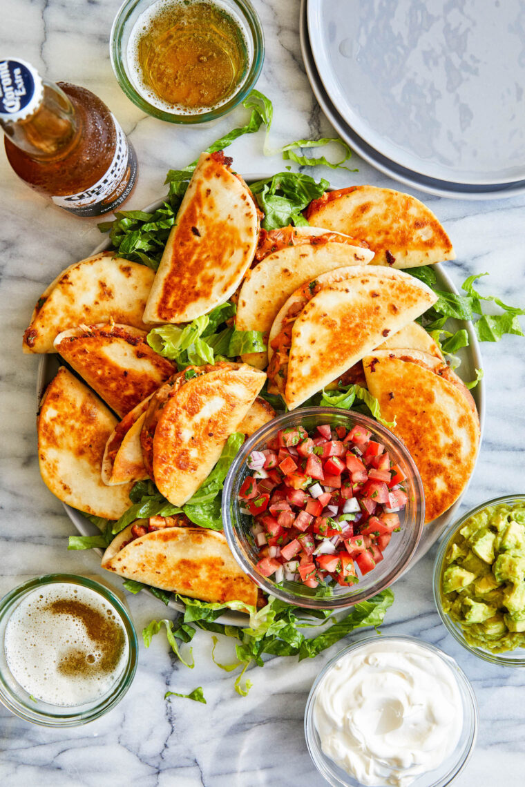 Mini Chicken Quesadillas - crowd-pleasing snack-sized quesadillas with refried beans, leftover rotisserie chicken + melted cheese!  So good!