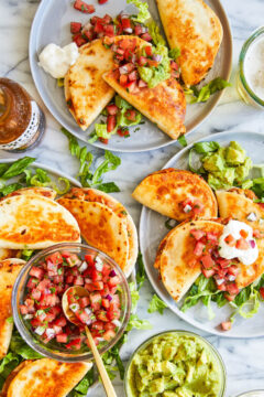 Snack-size quesadillas with refried beans, leftover rotisserie chicken, guacamole + melted cheese.