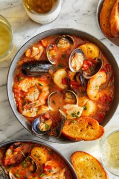 A Cioppino (seafood stew) made with clams, mussels, cod, shrimp and scallops served with slices of freshly toasted baguette.