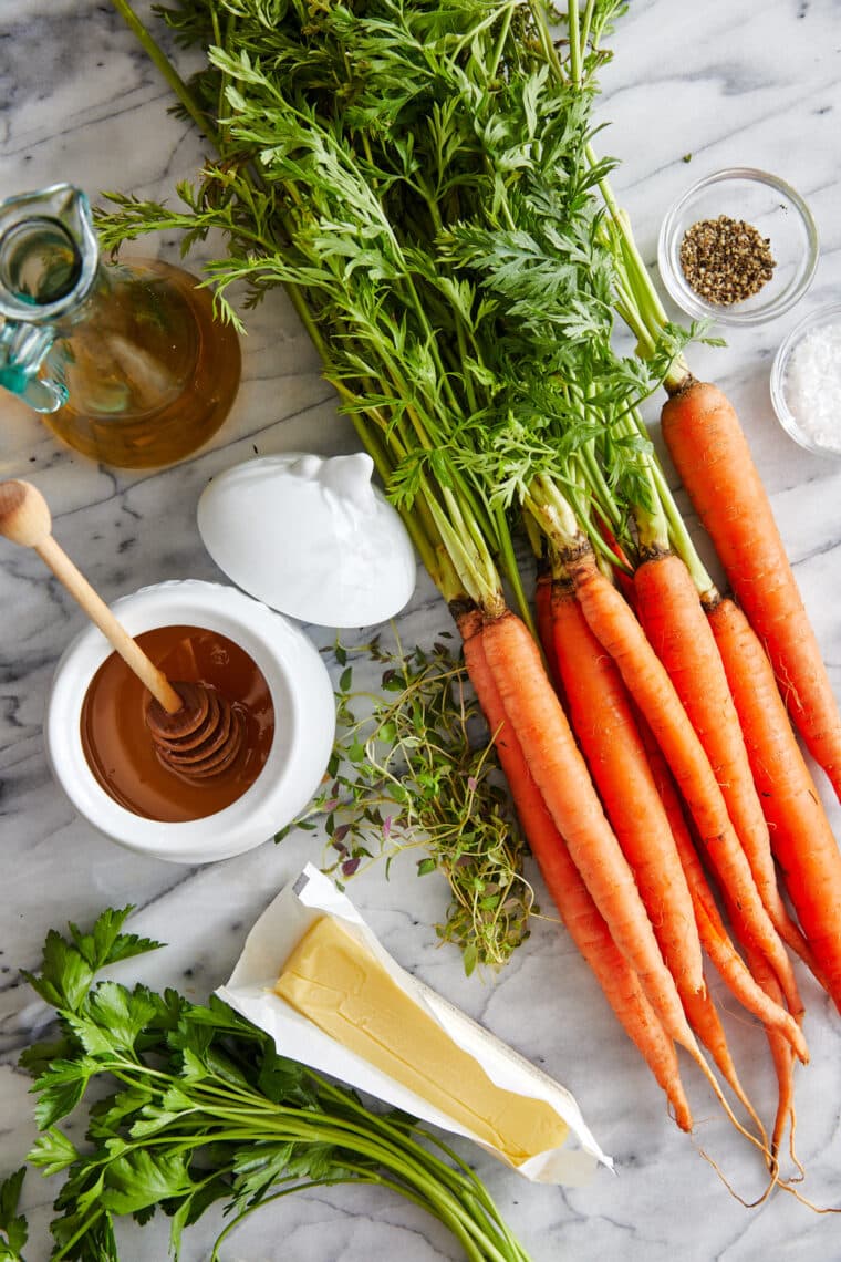 Glazed Carrots - Honey glazed carrots roasted to perfection, tossed in butter + fresh herbs. The easiest (and tastiest) side dish to any meal!