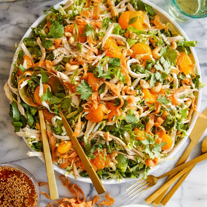 A rotisserie chicken salad with romaine lettuce, mandarin oranges, cilantro, onions, cashews and a sesame ginger dressing.