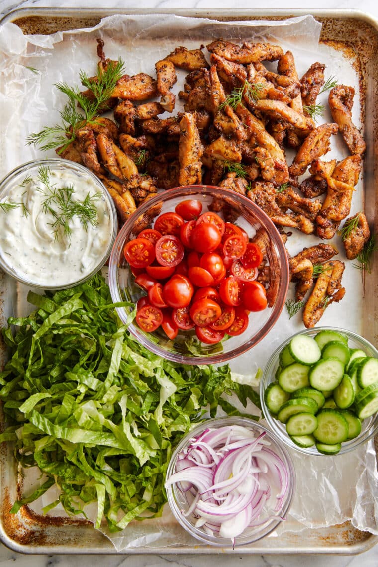 Sheet Pan Chicken Gyros - Perfect gekruide kip, tot in de perfectie gebakken op ÉÉN PAN!  Serveer in warme pitabroodjes voor een snelle doordeweekse maaltijd!