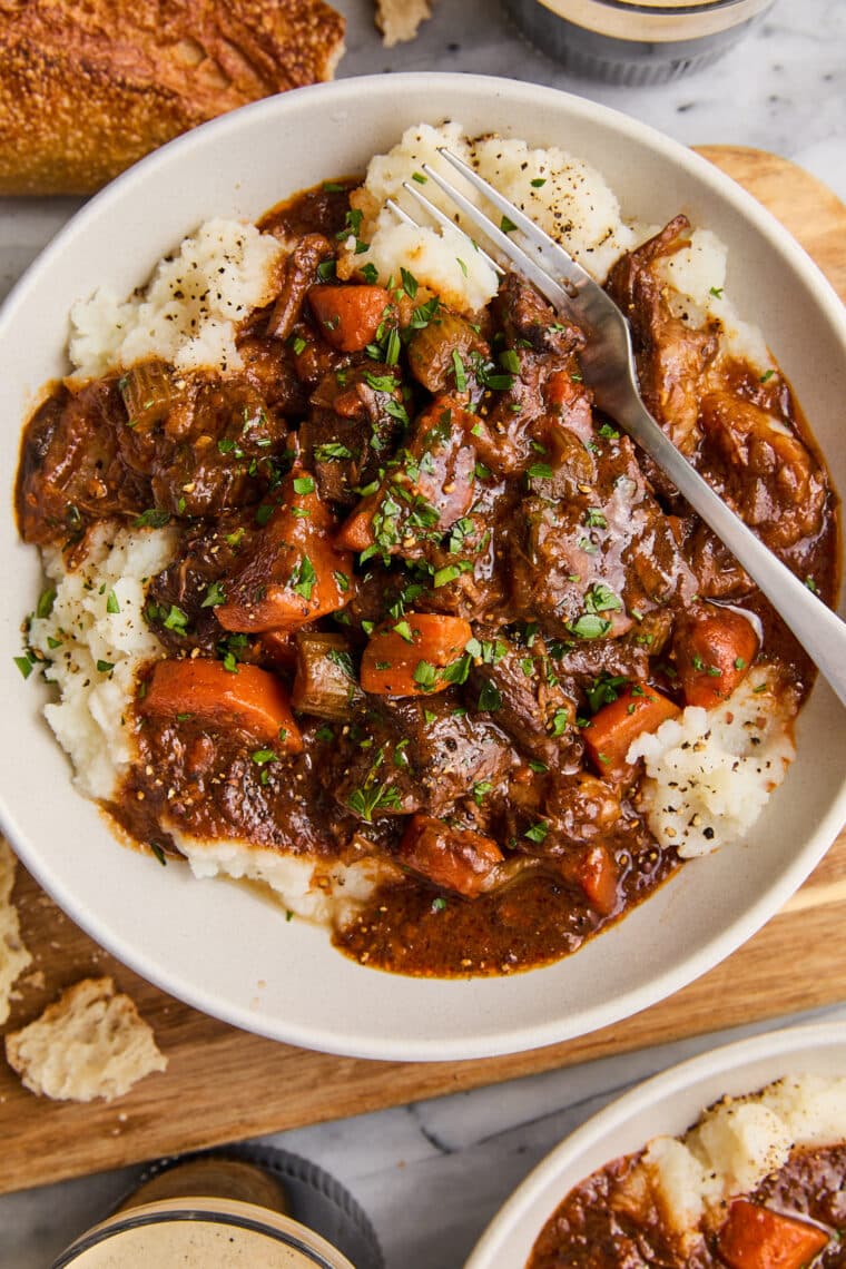 Guinness Beef Stew - A deep, rich beef stew so flavorful with veggies + the most tender fall-apart beef. Serve over mashed potatoes. So good!